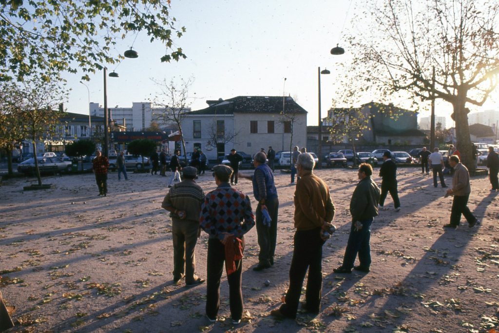 Joueurs de pétanque sur la place Jean-Jaurès, 1992. Photographie couleur, auteur inconnu. Archives communales de Mérignac, 19 Fi 49.