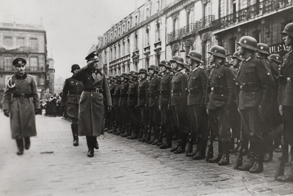 Revue des troupes, place Pey-Berland à Bordeaux, [1940-1944]. Photographie N et B, auteur inconnu. Archives de Bordeaux Métropole, Bordeaux 21 Fi 7.