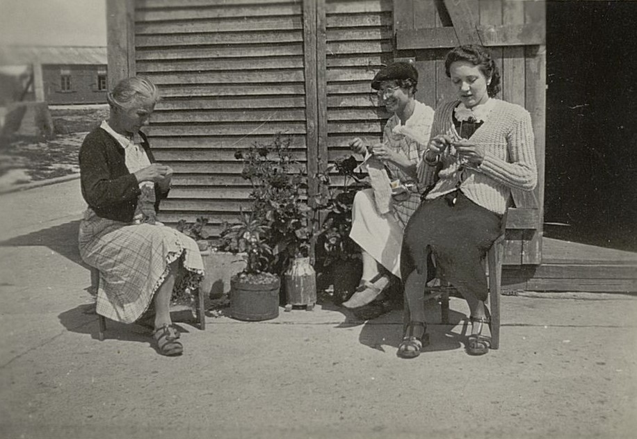 Femmes internées en train de tricoter et de coudre devant une baraque, s.d. Photographie N et B, auteur inconnu. Archives départementales de la Gironde. Fonds Georges-Durou, 142 J 77.